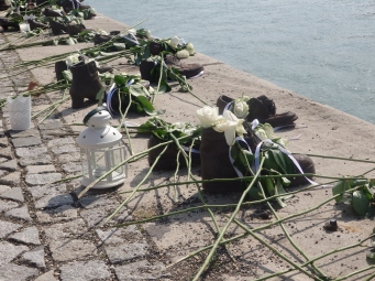 The Shoes on the Danube Bank, strewn with flowers and lanterns